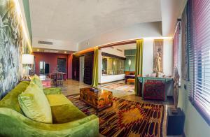 a living room with a green couch and a table at Lao Poet Hotel in Vientiane