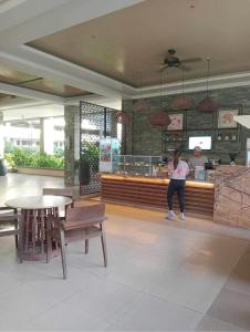 a woman standing at the counter of a restaurant at Verdon Parc Butterfly Haven in Davao City