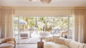 a living room with a couch and a patio at Designed By Three Birds Renovation in Pearl Beach
