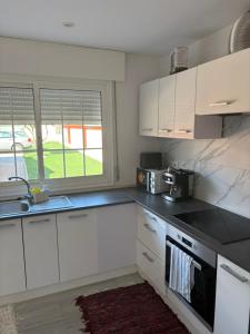 a kitchen with white cabinets and a sink at La calma de Aisheric in Nigrán