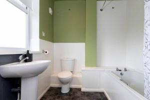 a bathroom with a sink and a toilet and a tub at 4BR Home with Parking Ideal for Contractors in Durham +15 photos