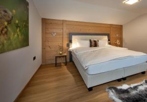 a bedroom with a large bed with a wooden headboard at Alpenchalet am Lech in Ehenbichl