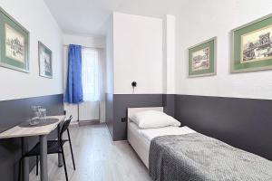 a bedroom with a bed and a table and a window at Dominik Panzió in Budapest