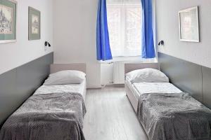 two beds in a room with a window at Dominik Panzió in Budapest