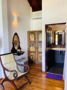 a room with a chair and a bathroom with a sink at The Villa Hotel in Unawatuna