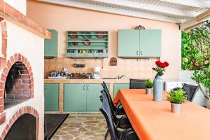 a kitchen with green cabinets and a table with chairs at Sand Garden Apart, Easy Stay by Heraklion Coast in Ayía Marína