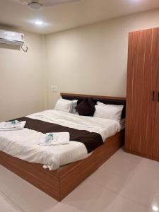 ein Schlafzimmer mit einem großen Bett, auf dem zwei Handtücher liegen in der Unterkunft Siya dormitory and rooms in Kolhapur