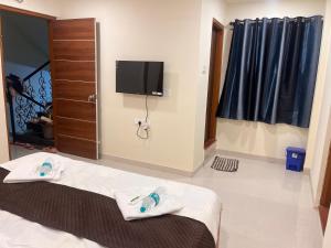 ein Hotelzimmer mit Bett und Flachbildfernseher in der Unterkunft Siya dormitory and rooms in Kolhapur