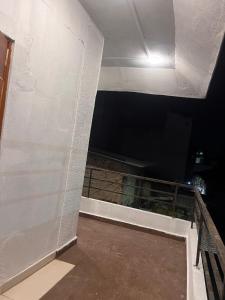 ein Zimmer mit einer weißen Wand und einem Balkon in der Unterkunft Siya dormitory and rooms in Kolhapur