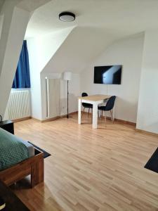 a living room with a table and a tv at Casa Maria Apartments Solothurn in Solothurn