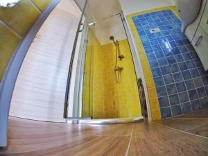 a bathroom with a shower with blue and yellow tiles at Aramoni B&B in Zambrone
