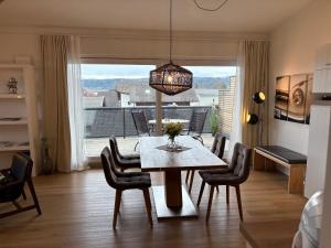 a dining room with a table and chairs and a large window at Terralpin - Wohnen auf Zeit - DG Wohnung mit Bergblick in Bruckmühl +19 photos