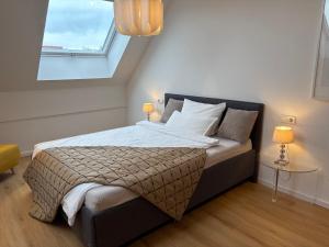 a bedroom with a large bed with two lamps at Terralpin - Wohnen auf Zeit - DG Wohnung mit Bergblick in Bruckmühl