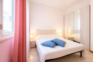 a bedroom with a bed with two blue pillows on it at Verdi Bilo Roseto Vacanza in Roseto degli Abruzzi