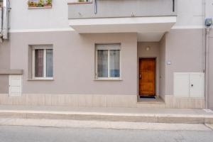 a white building with a brown door and windows at Verdi Bilo Roseto Vacanza in Roseto degli Abruzzi +2 photos