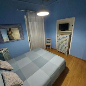 a bedroom with a bed and a dresser with a television at La casina di Silverio in Rio Marina