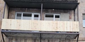 a wooden balcony on a building with two windows at Квартира in Jermuk +1 photo