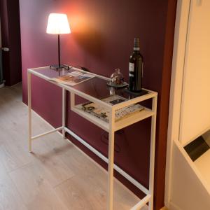 a table with a bottle of wine and a lamp on it at Gästehaus Vanille & Chocolat in Stolberg