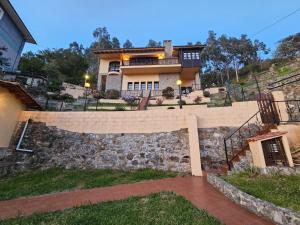 a house on a hill with a stone wall at Casa Villadam in Ribadesella