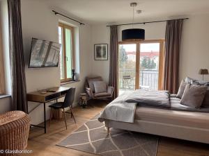 a bedroom with a bed and a desk and a window at Altstadtflair - Ruppin Quartier Stadtmitte in Neuruppin