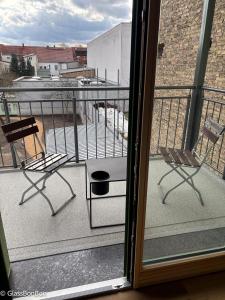 a balcony with two chairs and a view of a building at Altstadtflair - Ruppin Quartier Stadtmitte in Neuruppin