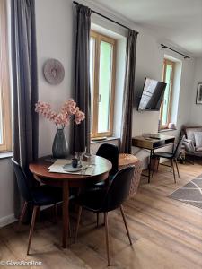 a dining room with a table and chairs and a room with a couch at Altstadtflair - Ruppin Quartier Stadtmitte in Neuruppin +12 photos
