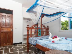 a bedroom with a bed with a canopy at Leopard House in Malindi +8 photos