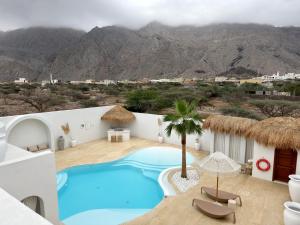 Ein Resort mit Swimmingpool und Bergen im Hintergrund in der Unterkunft Pool Villa Daya in Ras al Khaimah
