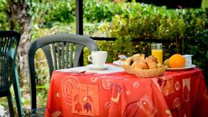 a table with a basket of bread and an orange juice at Logis Hostellerie du Neez in Gan