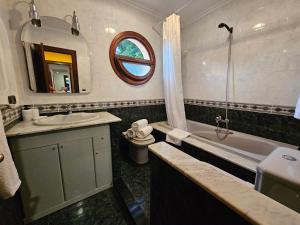 a bathroom with a sink and a tub and a toilet at Casa Villadam in Ribadesella +19 photos