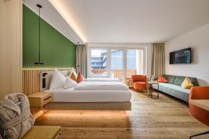 a hotel room with a bed and a couch at Impuls Hotel Tirol in Bad Hofgastein +103 photos