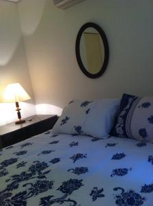 a bedroom with a blue and white bed with a mirror at Apartamento Zapata Guarujá in Guarujá +23 photos