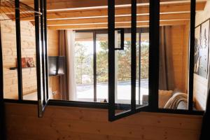a room with windows in a wooden house at Le Chalet aux Biches in Bolquere Pyrenees 2000