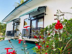 a house with a balcony and red flowers at Heaven Breeze Kandy in Kandy