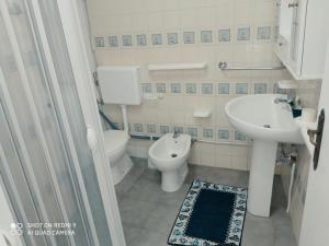 a white bathroom with a sink and a toilet at Mamalina Residence in Torre Pali +90 photos