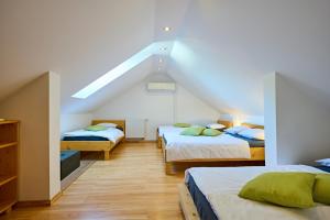 a attic room with three beds and a staircase at Guesthouse S in Luče