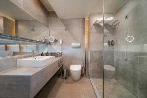 a bathroom with a sink and a shower at Kos Aktis Art Hotel in Kos +89 photos