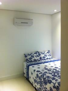 a bedroom with a bed and a air conditioner on the wall at Apartamento Zapata Guarujá in Guarujá