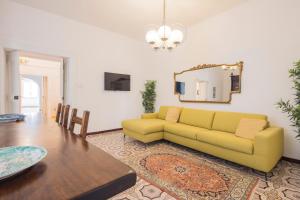 a living room with a yellow couch and a table at Residence Mareluna - Amalfi Coast by Mareluna Hotel in Vietri sul Mare