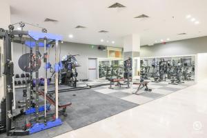 a gym with several treadmills and machines at فندق امضاء النزيل المدينة المنورة in Medina