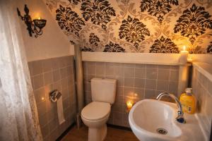 a bathroom with a toilet and a sink with lights at Das blaue Haus - Huize Hubertus in Sankt Andreasberg