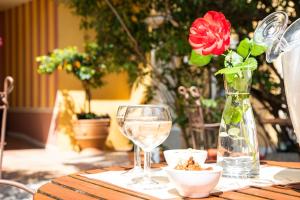 a table with a vase with a flower and a glass at La Bastide Du Port - Hôtel de Charme in Saint-Tropez
