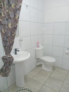 a white bathroom with a toilet and a sink at Duminy Guesthouse in Bellville