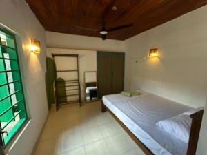 a bedroom with a bed and a window at Jungle Flower Town in Matara