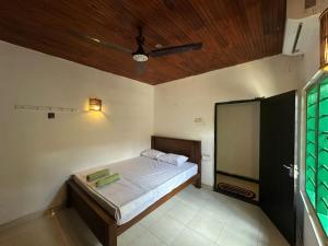 a bedroom with a bed with a wooden ceiling at Jungle Flower Town in Matara