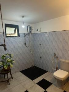 a bathroom with a toilet and a shower at Jungle Flower Town in Matara