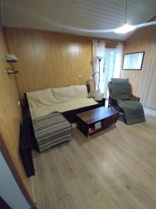 a bedroom with a bed and a couch and a chair at Sosnowy Zakątek, Laskowo in Laskowo