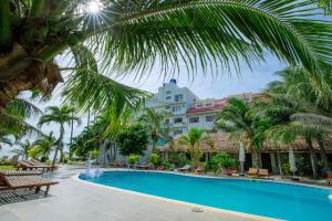 a pool in front of a hotel with palm trees at Matie Beach Hotel & Resort in Kao Kuil