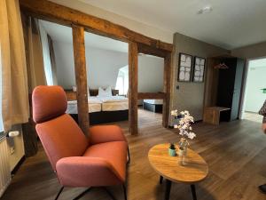 a living room with a chair and a table at Hotel und Restaurant Hohe Schule in Herborn