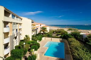 un appartement avec une piscine à côté d'un bâtiment dans l'établissement Vacancéole - Savanna Beach- Terrasses de Savanna, au Cap d'Agde